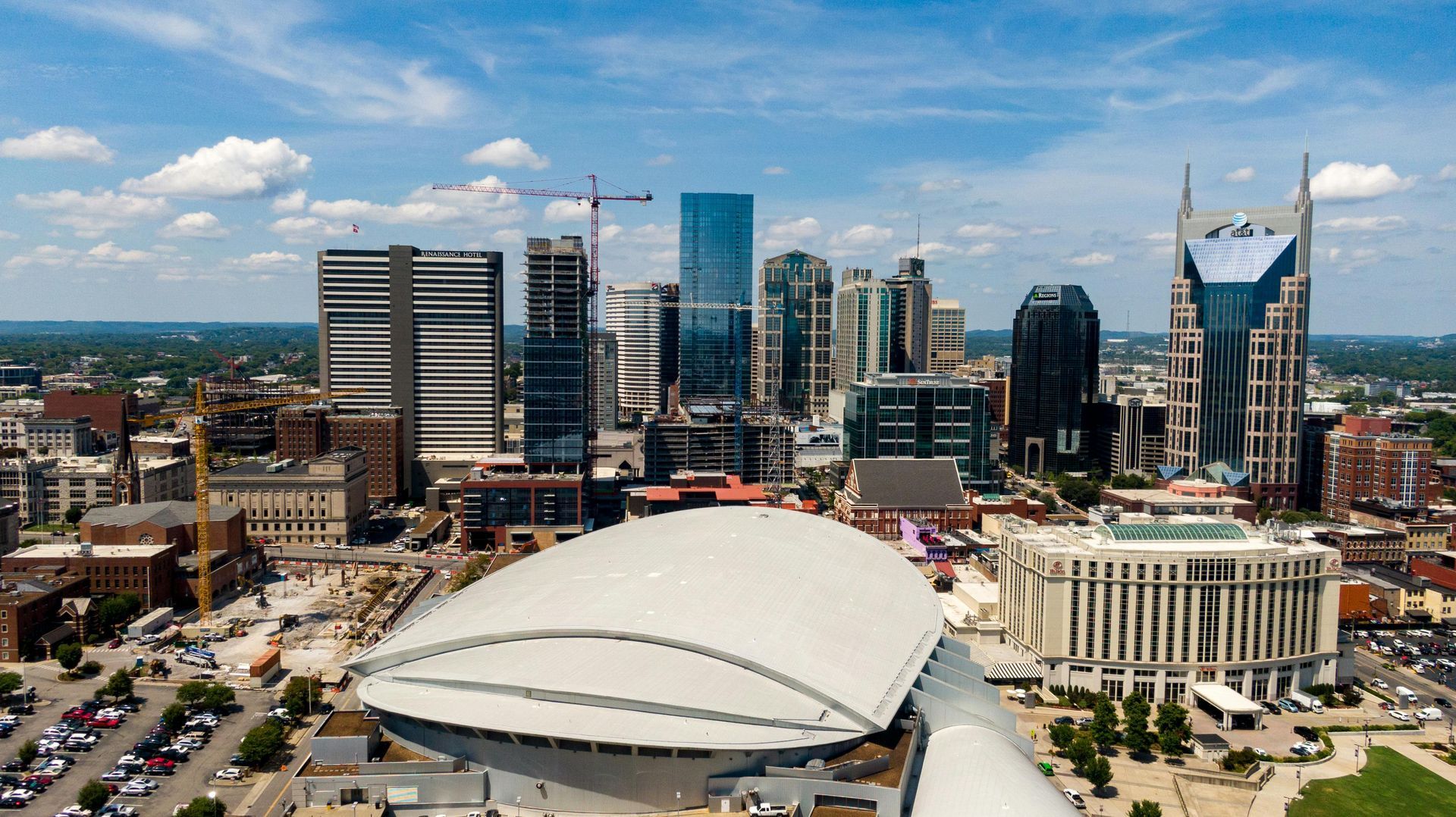 Downtown skyline with a white domed stadium in the foreground and tall modern buildings behind it.