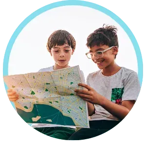 Two children smiling and looking at a map inside a light blue circle
