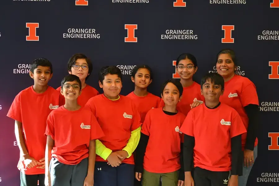 Group of students in red shirts posing in front of a Granger Engineering backdrop