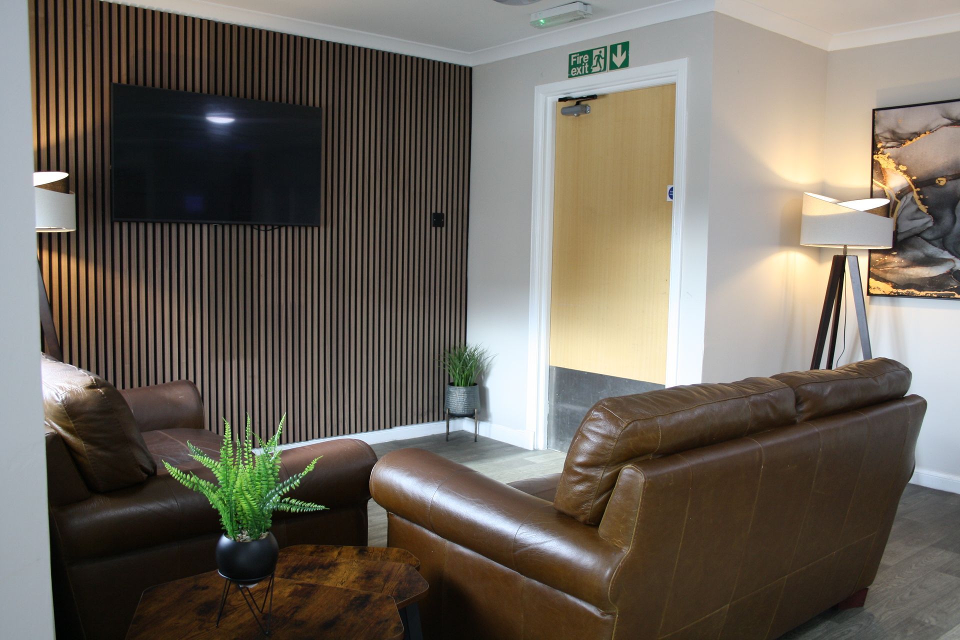 A living room with a couch , chair , table and television.