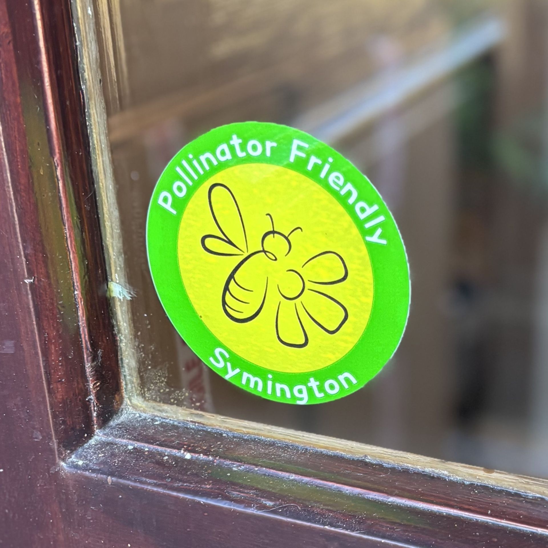 A pollinator friendly symington sticker on a window