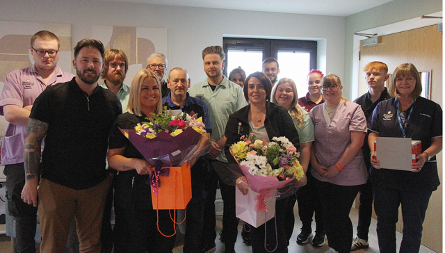 Whiteford House staff standing next to each other holding flowers.