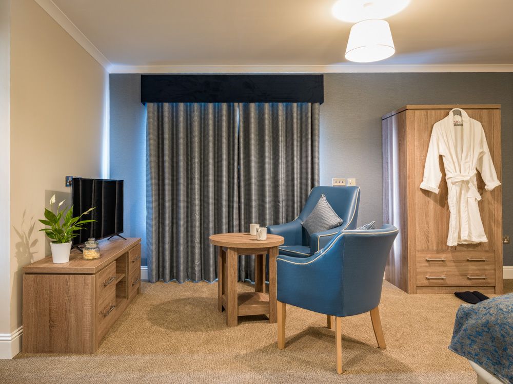 Atlantic view room with a chair, table, and television.