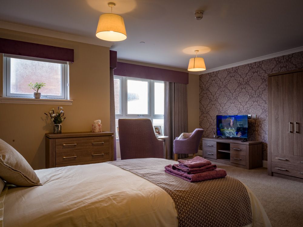 Atlantic View bedroom with a bed, chair, dresser and television.