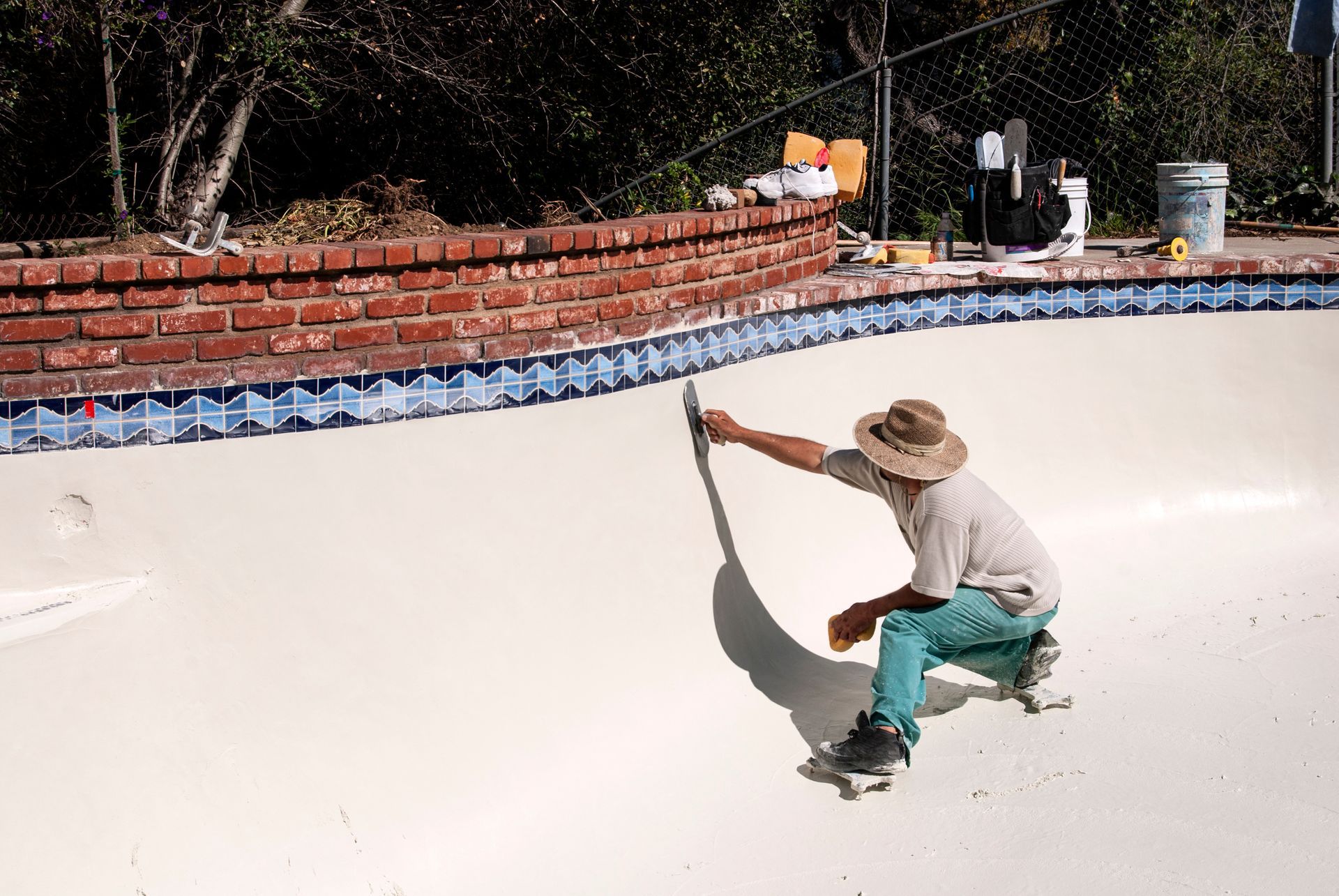 Mason smoothing plaster in a new swimming pool. Mason smoothing plaster in a new swimming pool.