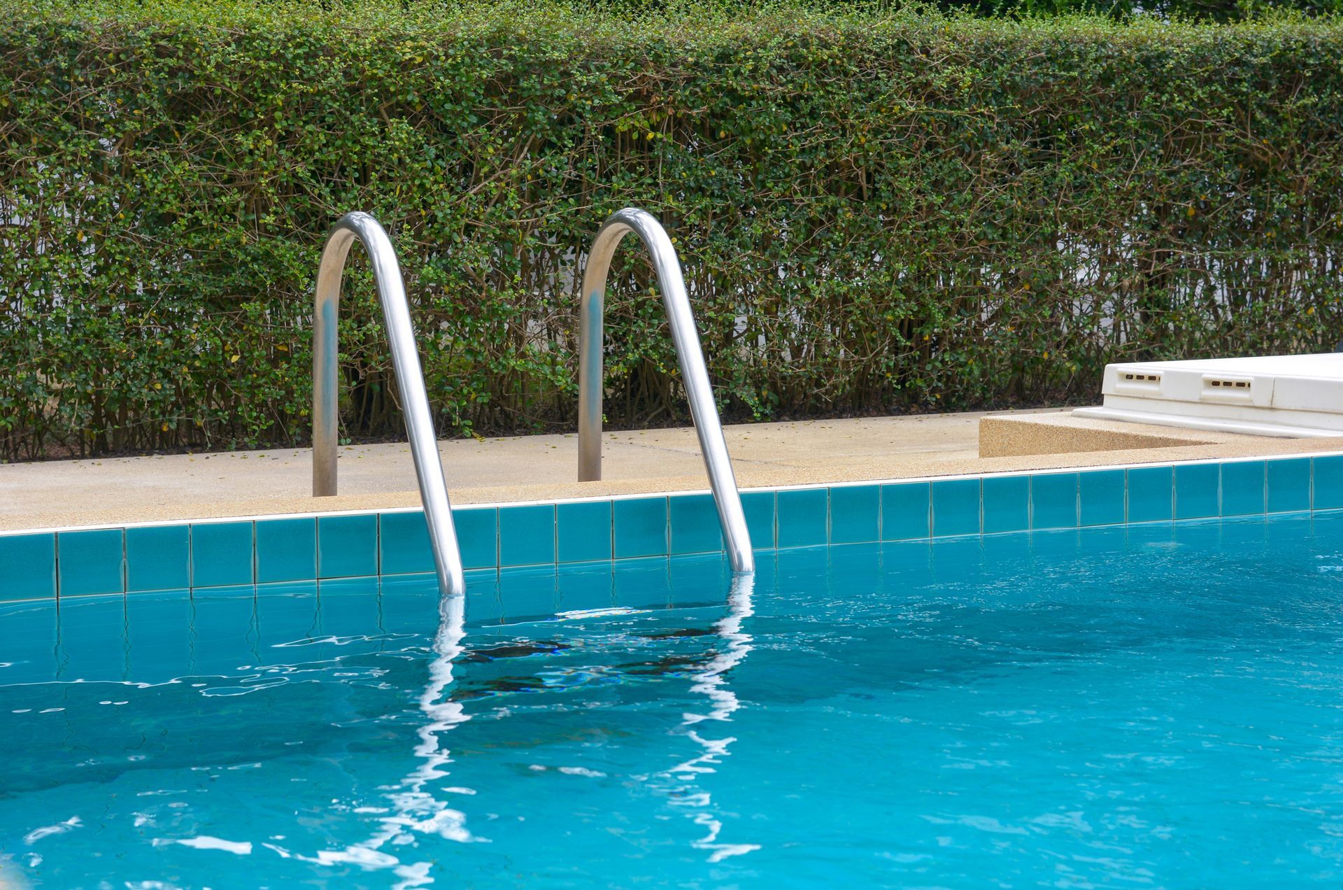Metallic pool stairs that lead to the inside of a full pool.