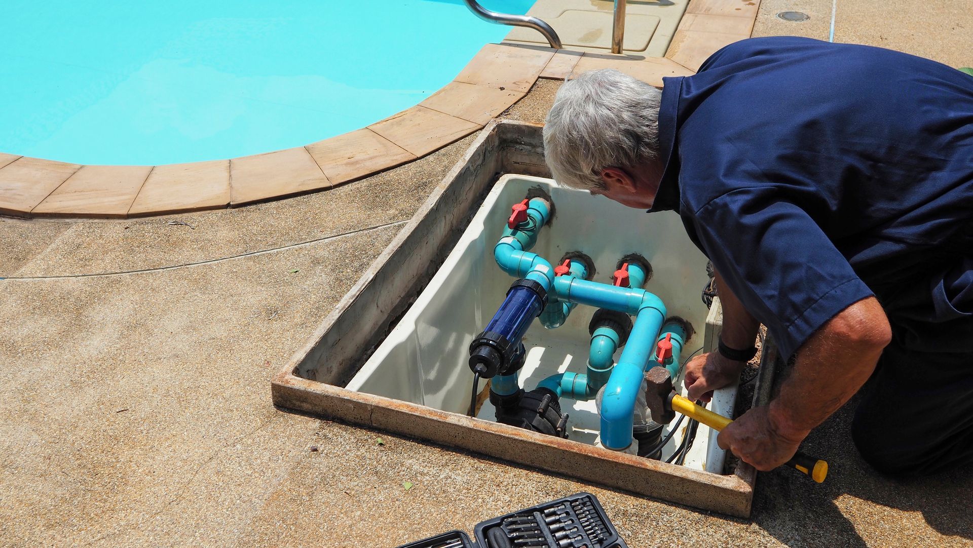 Technician ensuring functionality of a swimming pool water pump. Technician ensuring functionality of a swimming pool water pump.