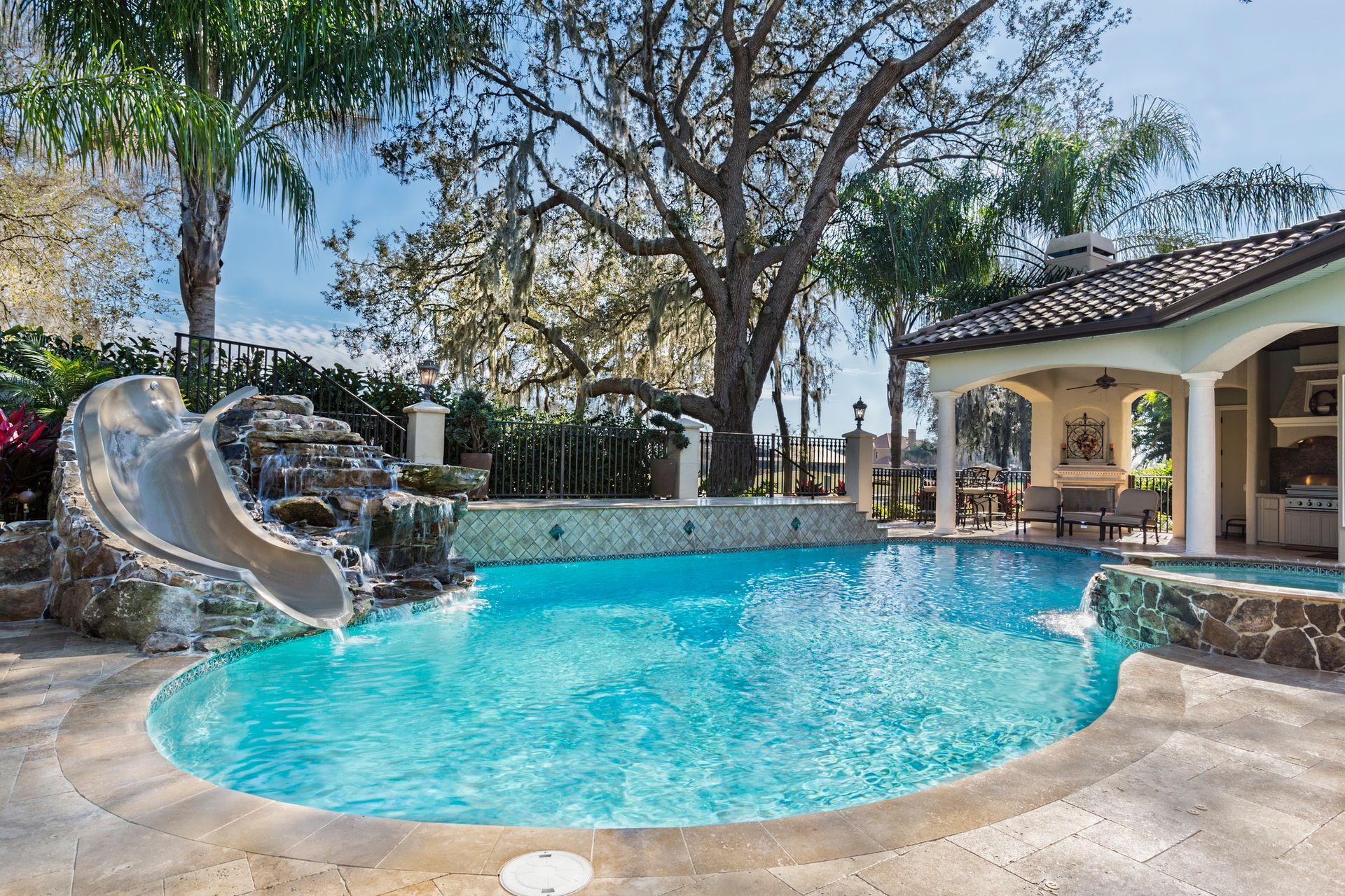 Custom swimming pool with slide, spa, and waterfall designed by Clear Blue Pools for swimming pool d