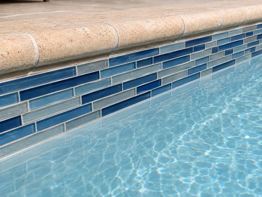 Blue glass waterline tile and stone coping on a renovated pool in Kiawah Island, SC