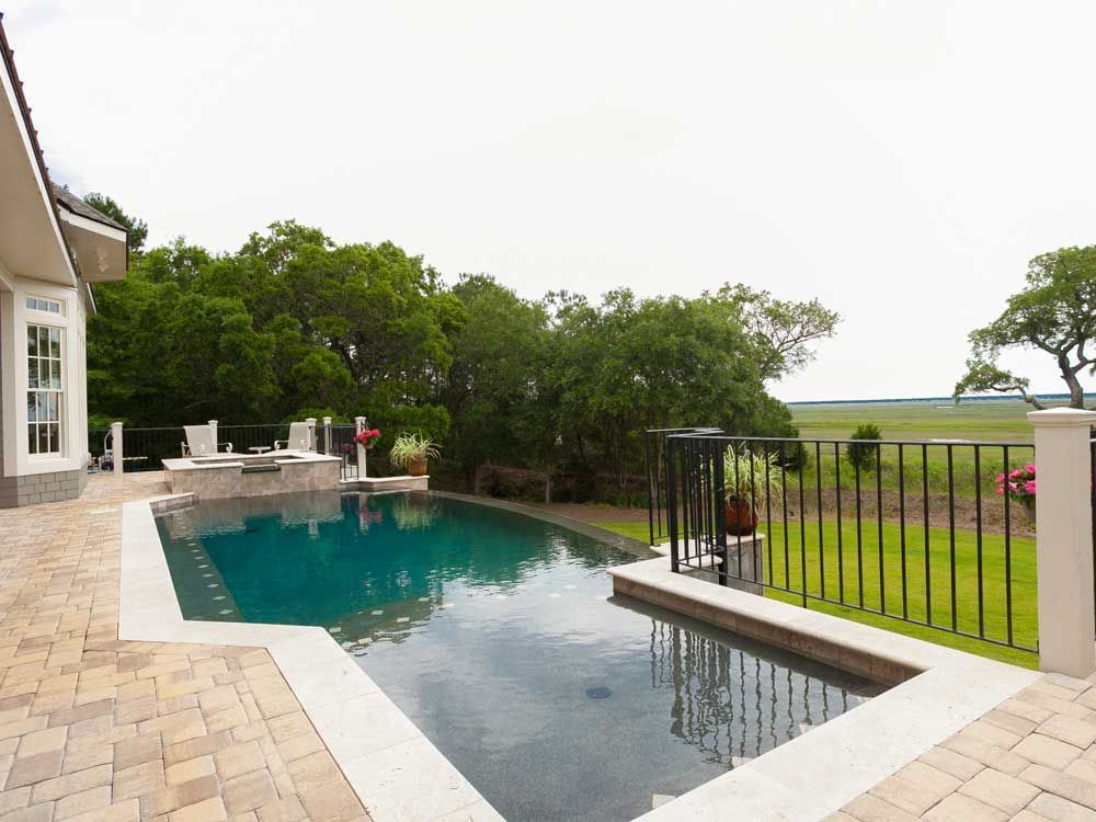 A house with a large swimming pool in front of it