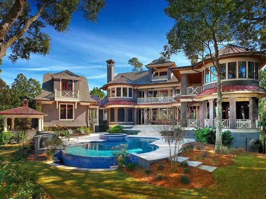 A house with a large swimming pool in front of it