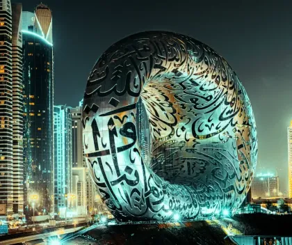 Futuristic city skyline with a giant illuminated Arabic calligraphy sculpture at night