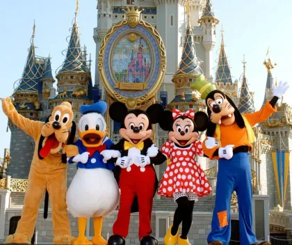 Mickey, Minnie, Donald, Goofy, and Pluto posing in front of Cinderella Castle at Disney World