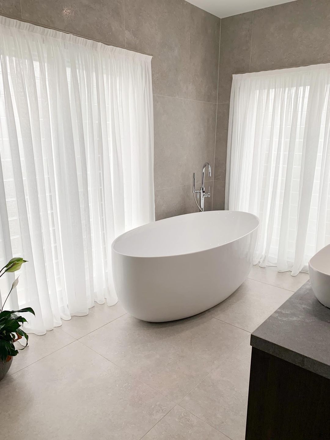 A Bathroom With A Bathtub And A Sink In Front Of A Window — Ron Ayton Curtains, Blinds & Shutters In Shelly Beach, NSW