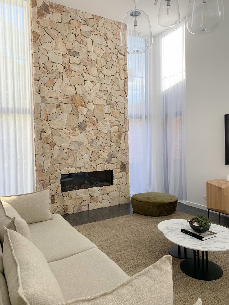 A Living Room With A Couch, Coffee Table, And Fireplace — Ron Ayton Curtains, Blinds & Shutters In Caves Beach, NSW