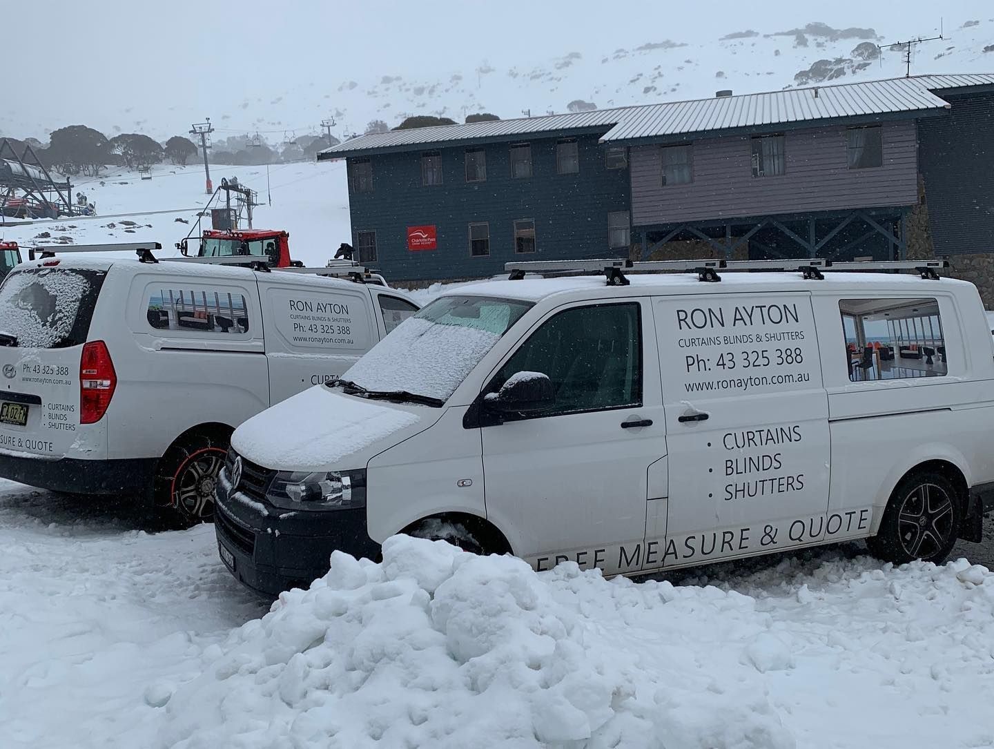 Two vans are parked in the snow in front of a building. — Ron Ayton Curtains, Blinds & Shutters In Shelly Beach, NSW