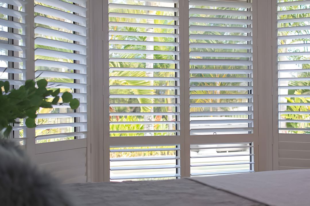 A Bedroom With Shutters On The Windows And A Bed — Ron Ayton Curtains, Blinds & Shutters In Hunter Valley, NSW