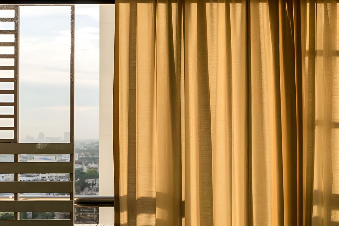 A Room With A Sliding Glass Door And Yellow Curtains — Ron Ayton Curtains, Blinds & Shutters In Shelly Beach, NSW