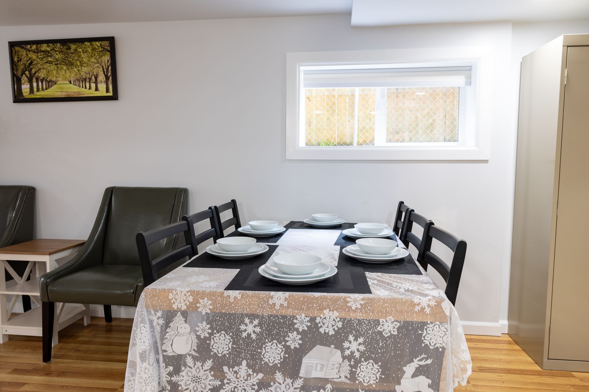Dining room with a table set for six, a framed picture, and a window.