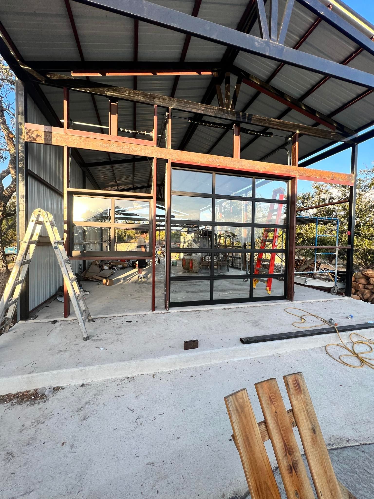 A wooden chair is sitting in front of a building under construction.