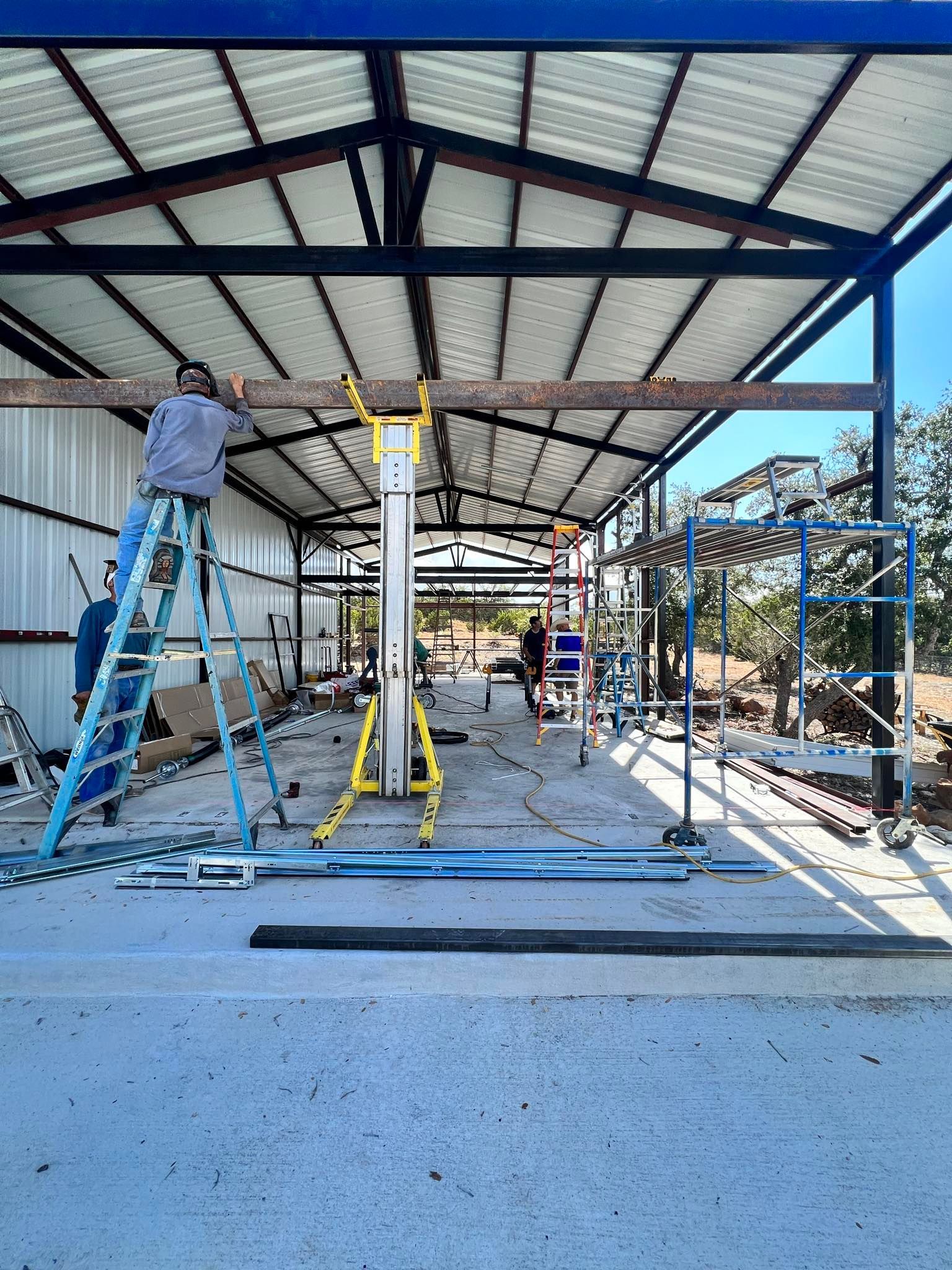 A man is standing on a ladder in a building under construction.