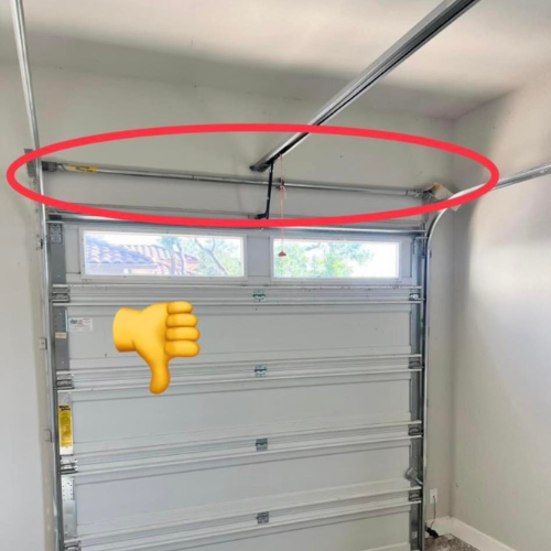 A picture of a garage door with a thumbs down sign next to it.