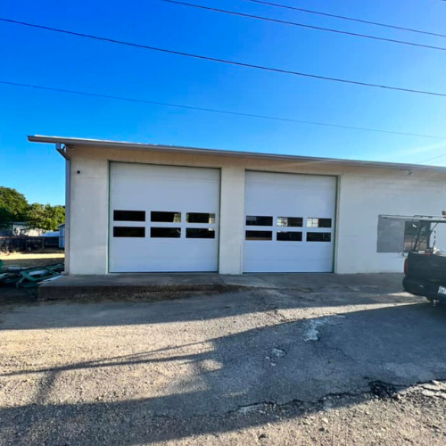 A truck is parked in front of a white garage door