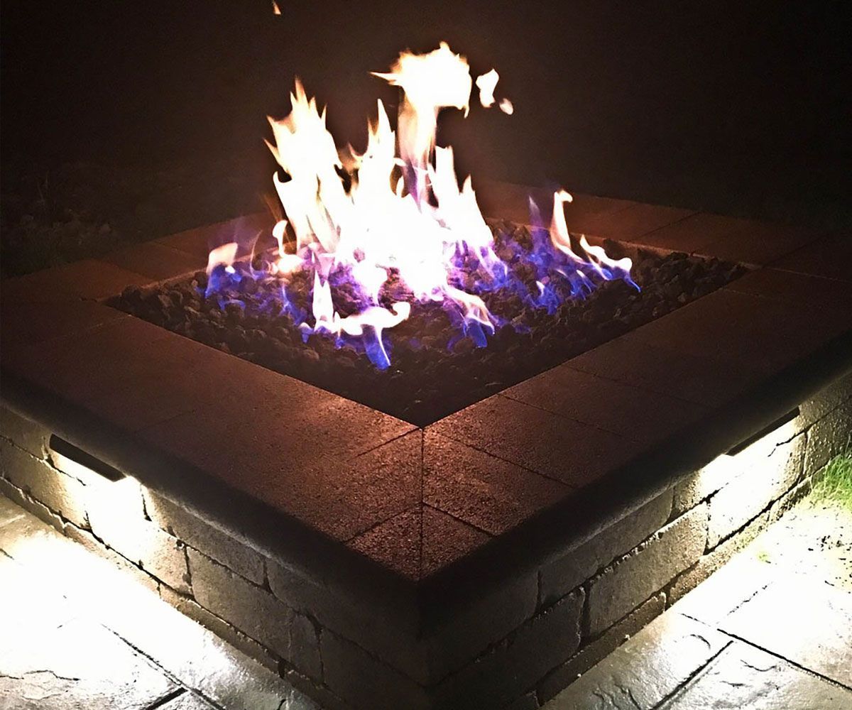 Backyard patio square gas fire pit with fire lava rocks in Cleveland area home.