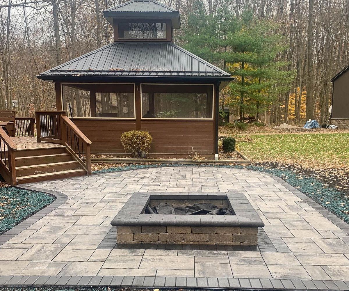 Modern rectangular outdoor fire pit near backyard gazebo in Summit County, Ohio.