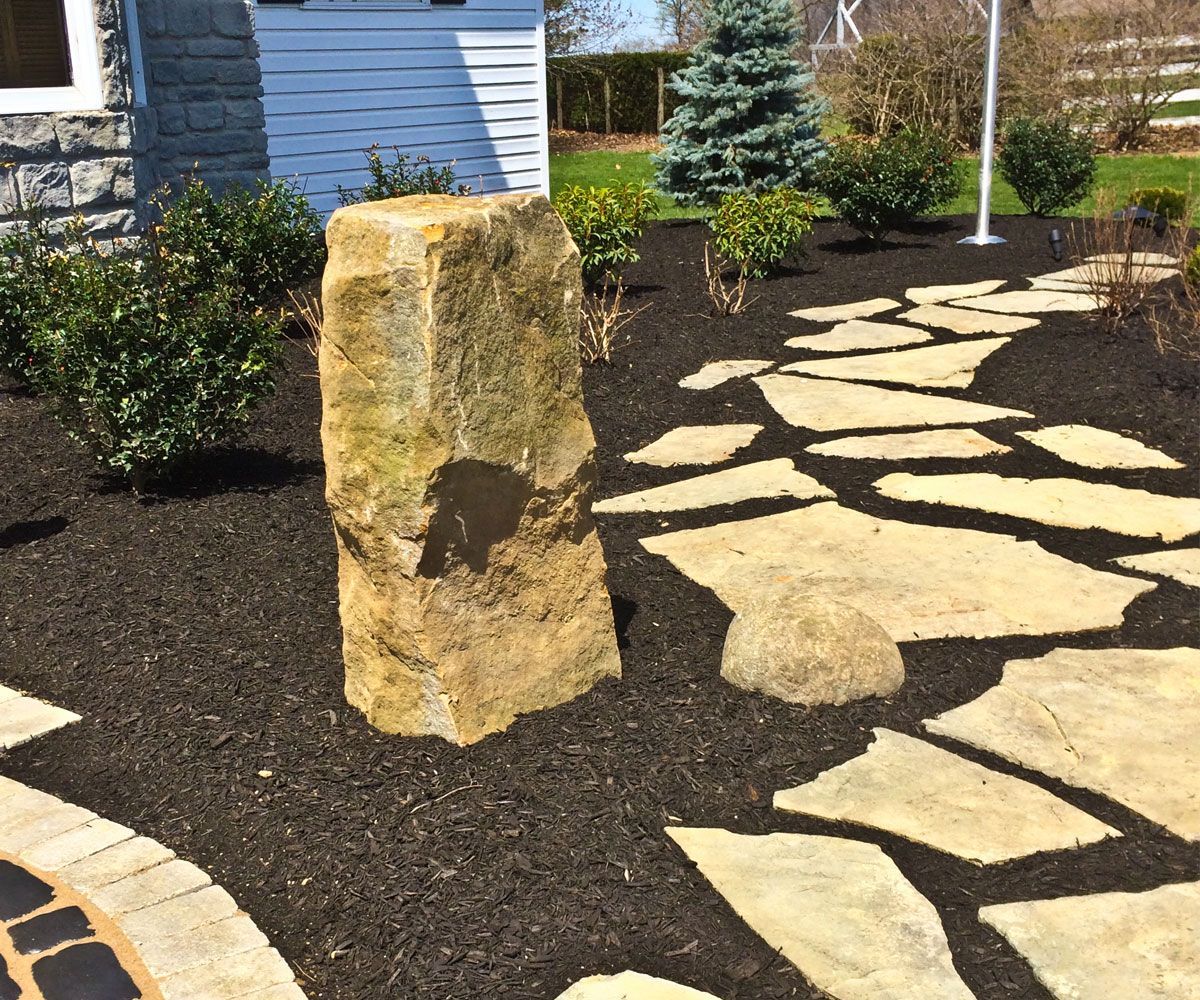 Natural barnstone column water feature bubbler fountain by flagstone patio in Bath, OH landscape