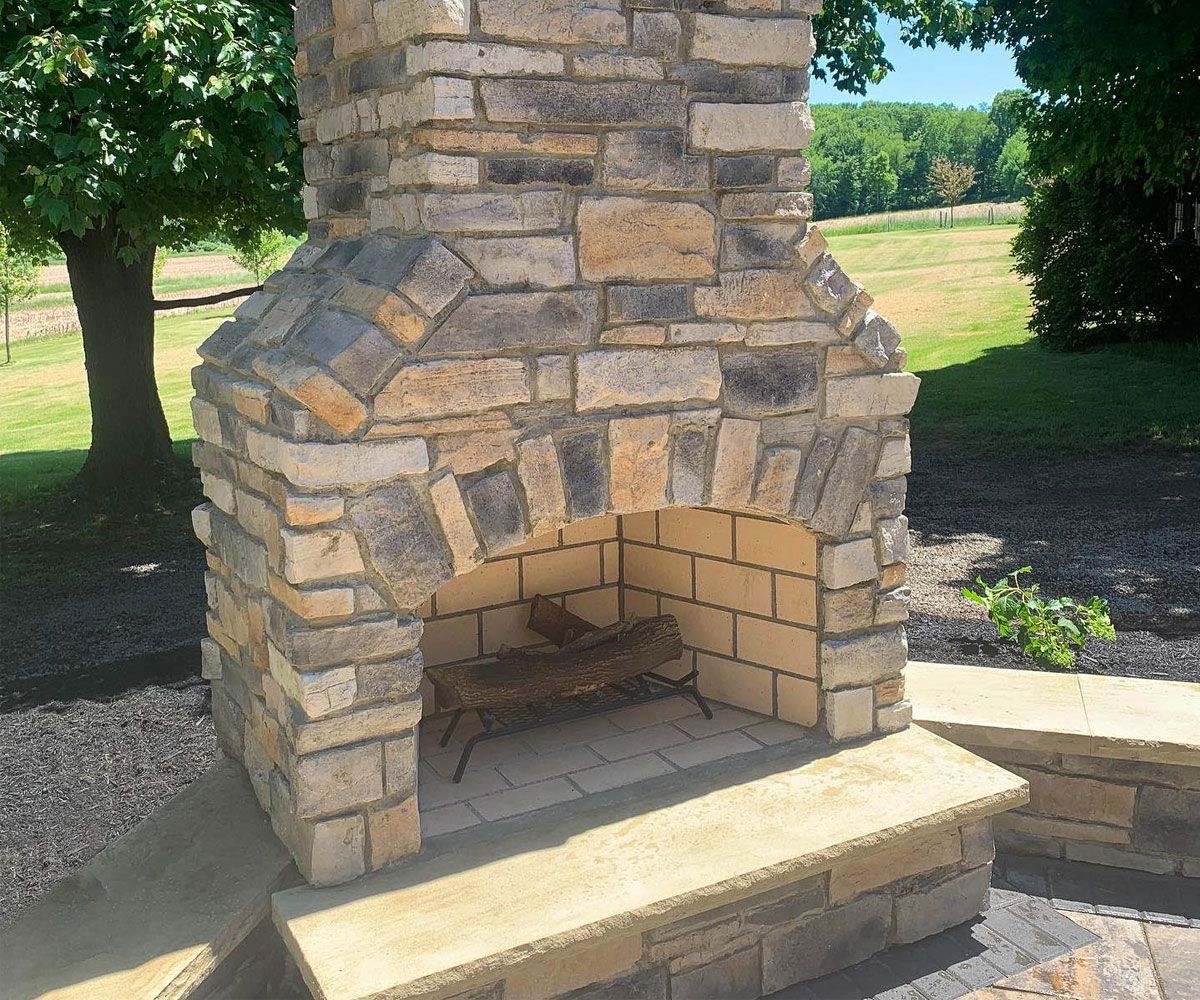 Custom outdoor stone fireplace in Sharon Center, OH designed and installed by Chidsey Landscape & Design