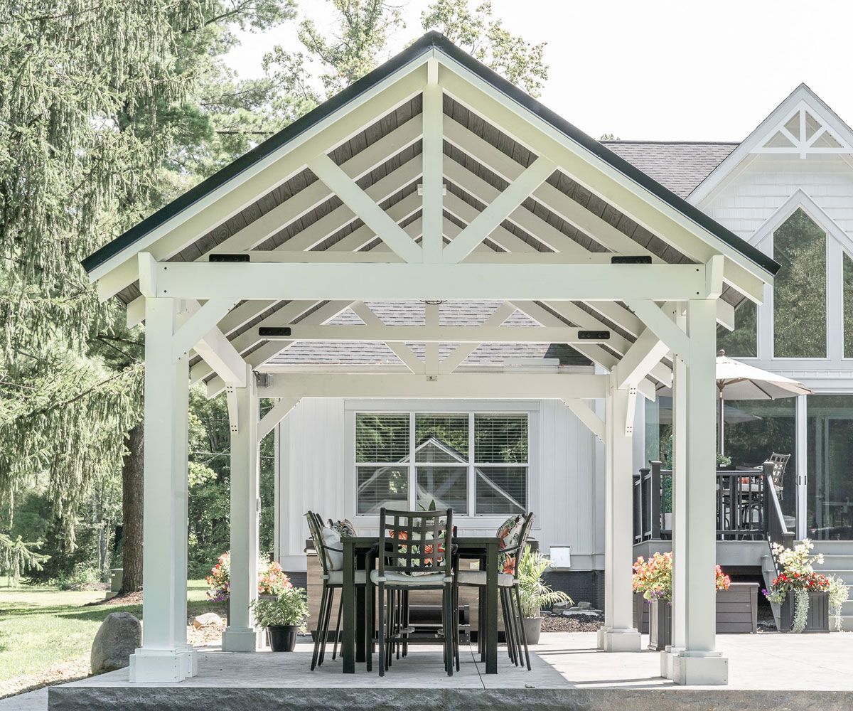 White vinyl backyard pavilion with slat roof covering outdoor kitchen area of Summit County, OH home.