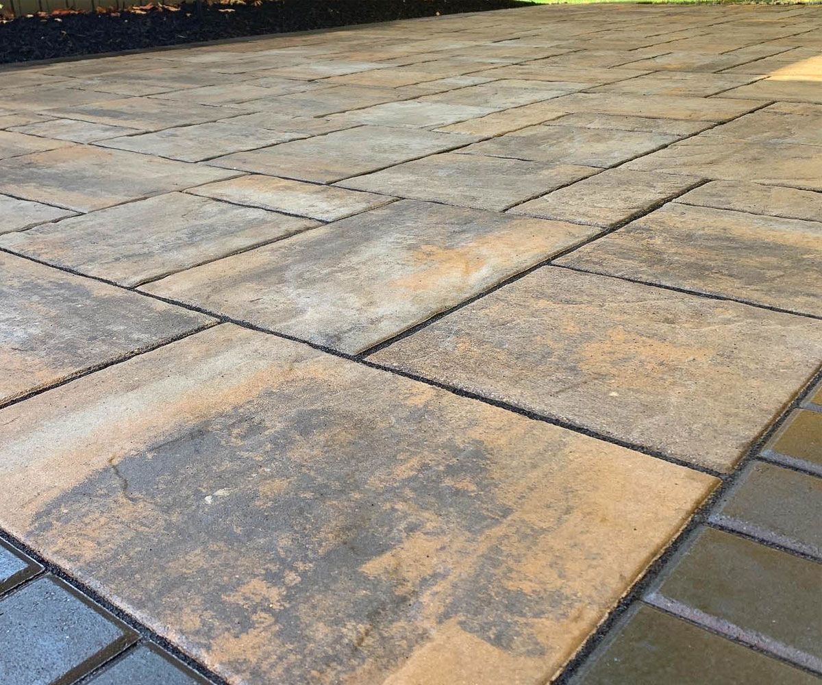 Textured brown large paving stone patio with dark accent patio paver border in Cuyahoga County, Ohio
