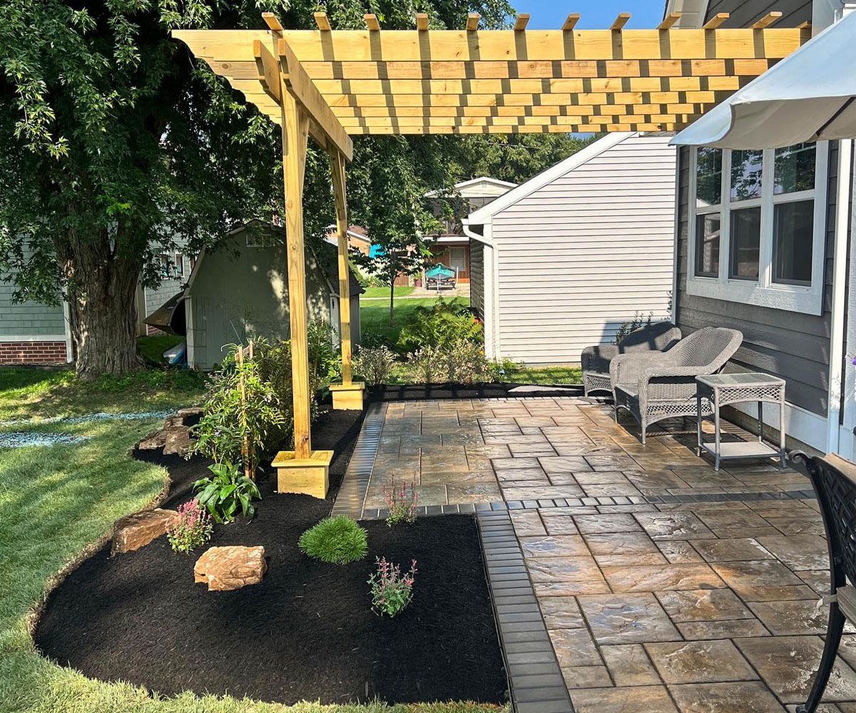 Backyard patio with wooden pergola in Northeast Ohio installed with Unilock paving stones from Chidsey Landscape & Design