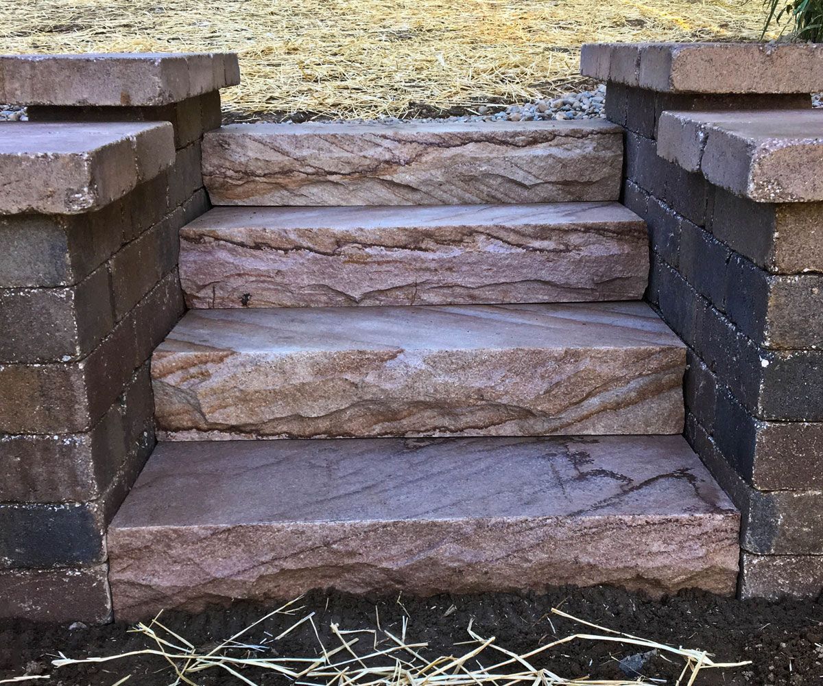 Large natural sandstone steps in between Medina hardscape retaining wall designed by Chidsey Landscape & Design