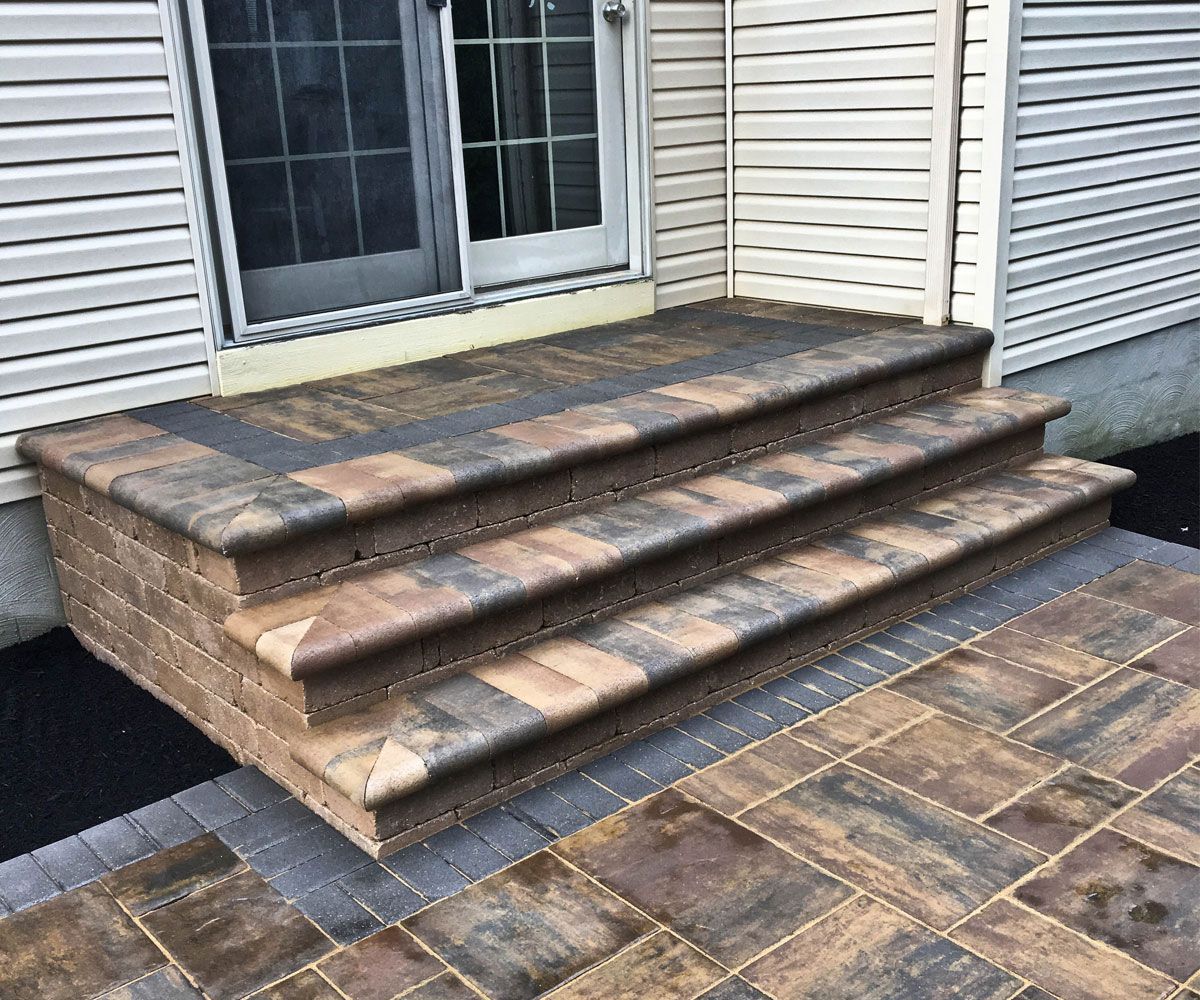 Paving stone steps from house down to Northeast Ohio hardscape patio with border and garden beds