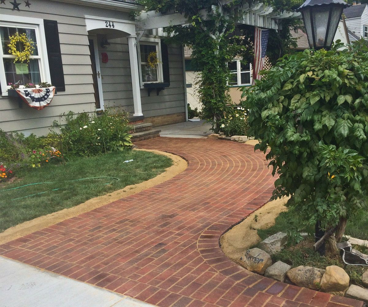 Custom paving stone walkway at front entrance of Fairlawn, OH home with herringbone pattern.