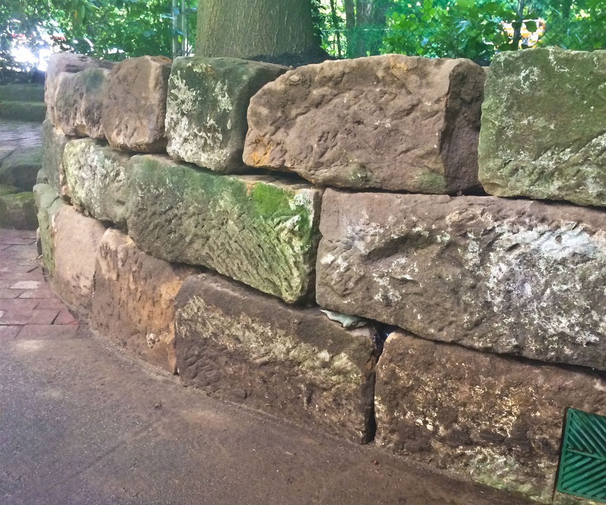 Natural stone outcropping retaining wall for soil erosion control solution in Cuyahoga County driveway