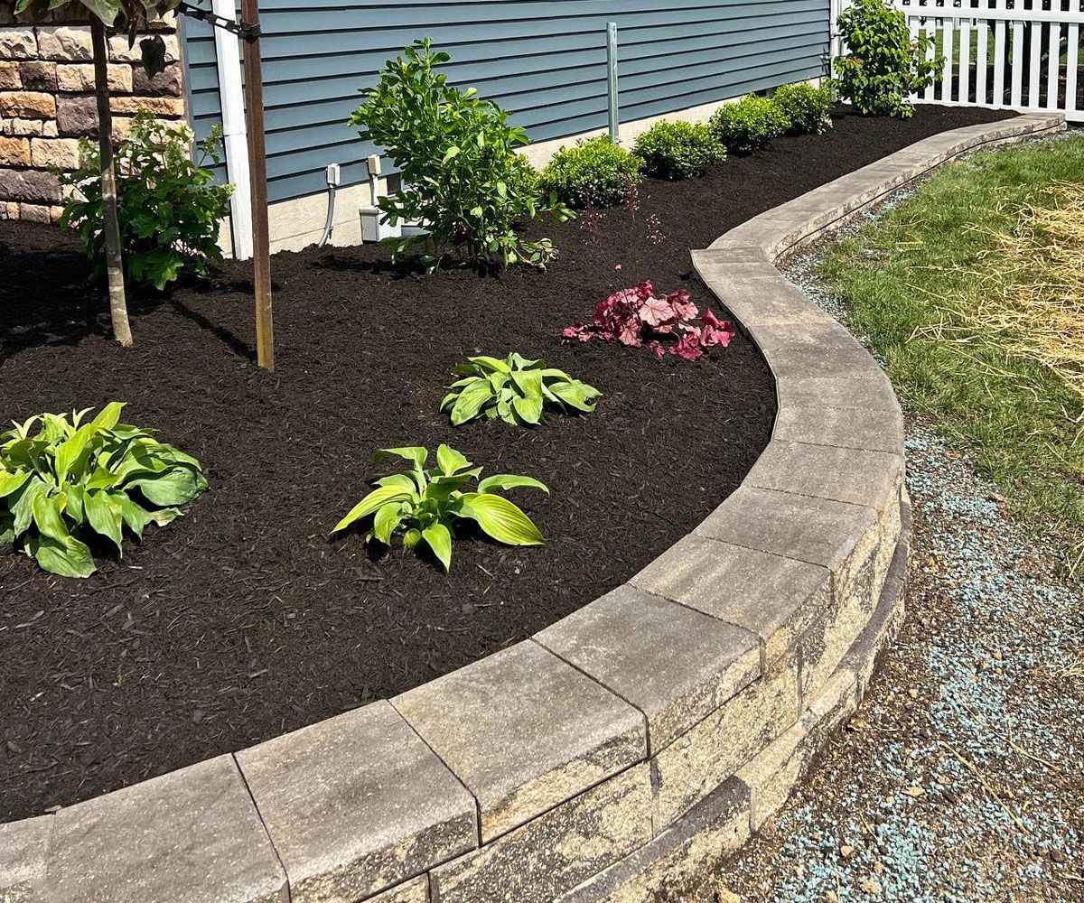 Paving wall stone block retaining wall on sloped front yard in Wayne County Ohio to help with water runoff