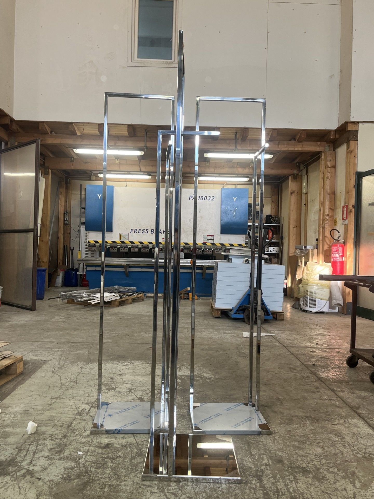 Scaffalature in metallo cromato esposte in una stanza non rifinita con pareti blu e struttura a vista.