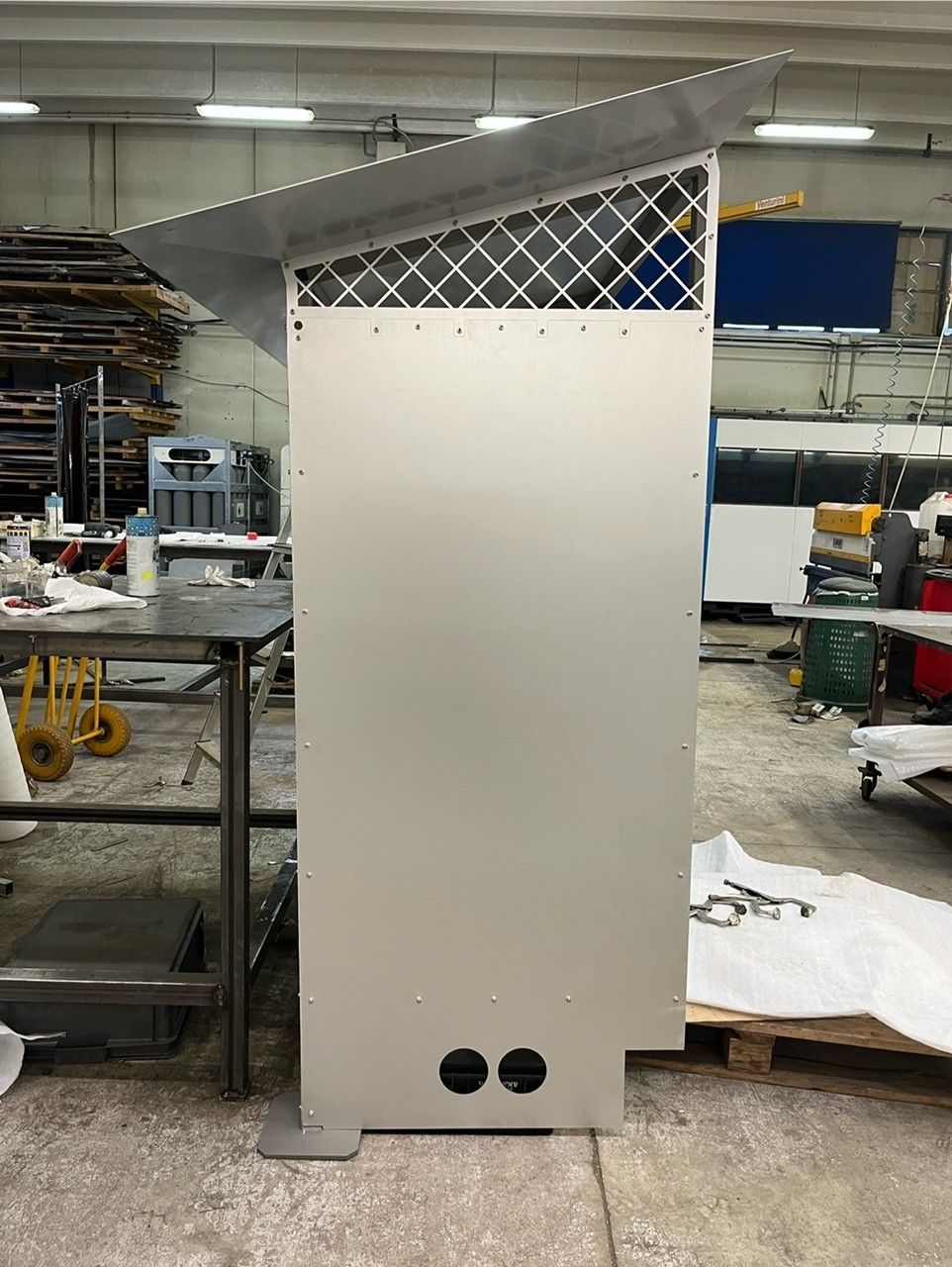 Armadio o contenitore in metallo bianco per officina, con piano a griglia e due aperture circolari vicino alla base.