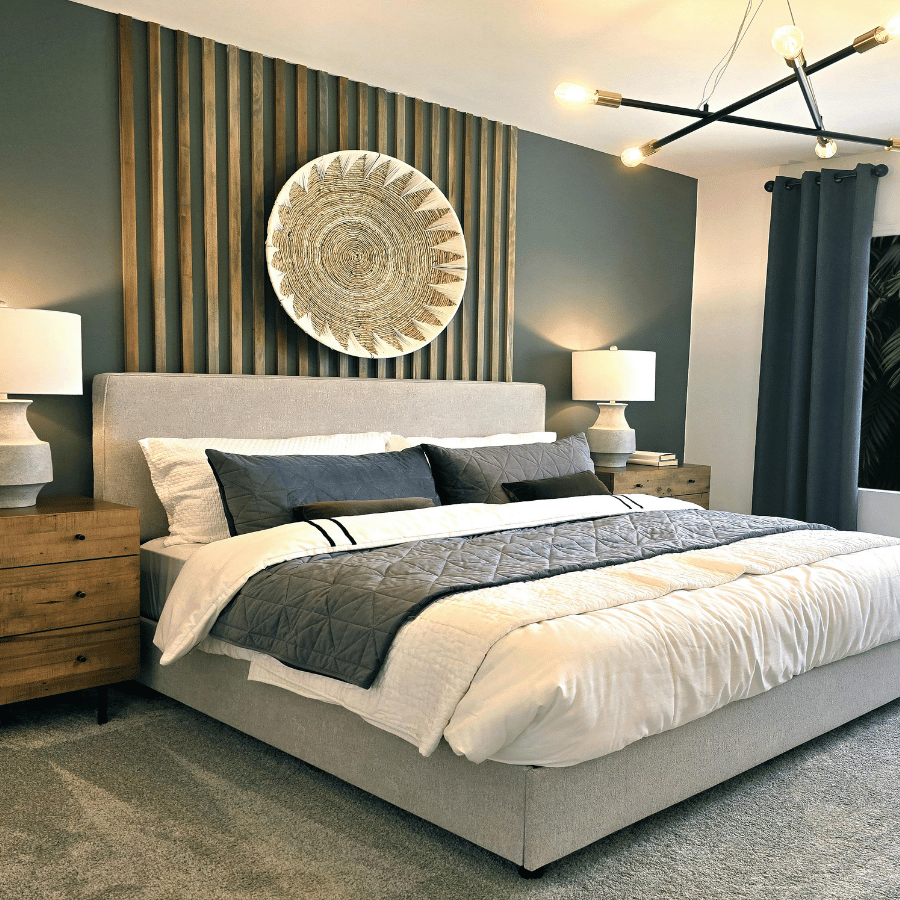 Modern bedroom with a king bed, dark accent wall, wood nightstands, and decorative wall art