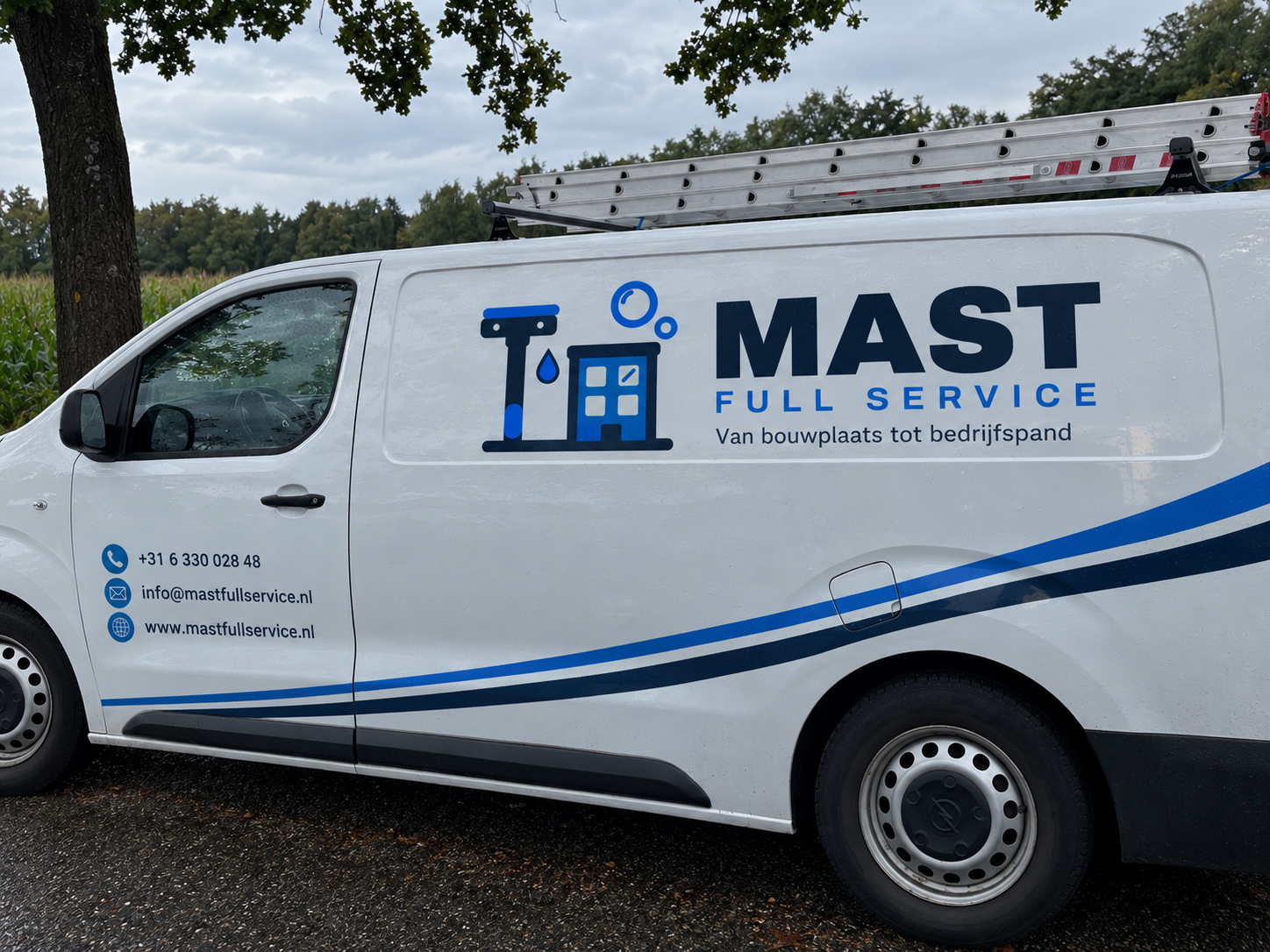 Bedrijfsbus van Mast Full Service met belettering