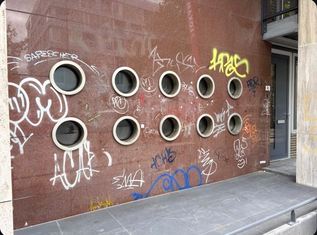 Dezelfde gevel voor de reiniging, beklad met graffiti