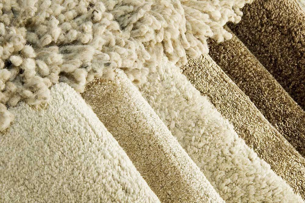 A Close Up Of A Stack Of Different Colored Carpets — Encore Carpet Professionals in Helensvale, QLD