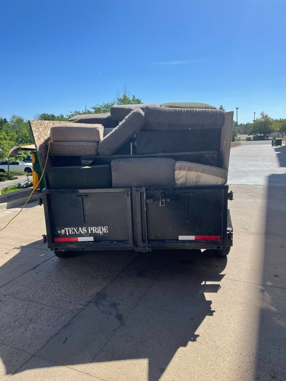 dark blue dumpster in front of a white residential garage