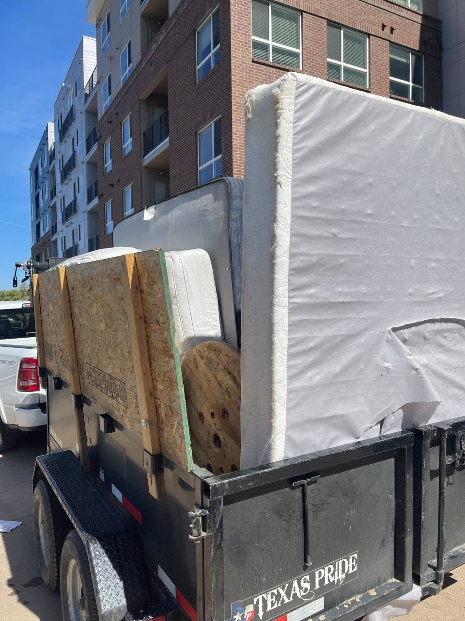 blue dumpster full of wood and other debris in front of house garage