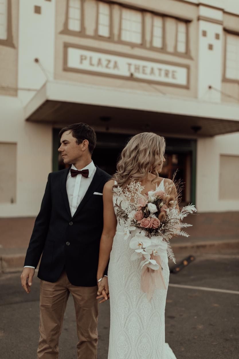 Couple Holding Hands in Front of The Plaza Theatre — Denise's Flower Studio In Dubbo, NSW