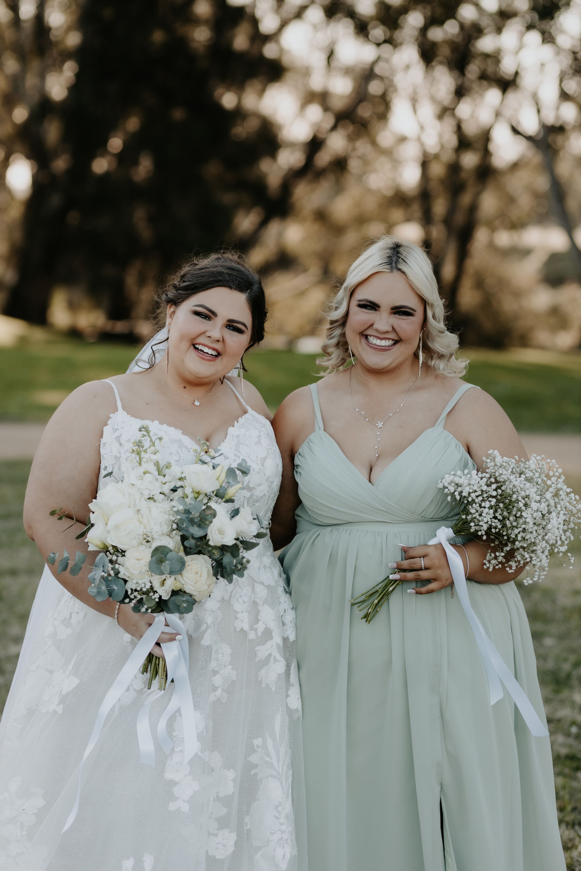 Bride and Bridesmaid Smiling Outdoors — Denise's Flower Studio In Dubbo, NSW
