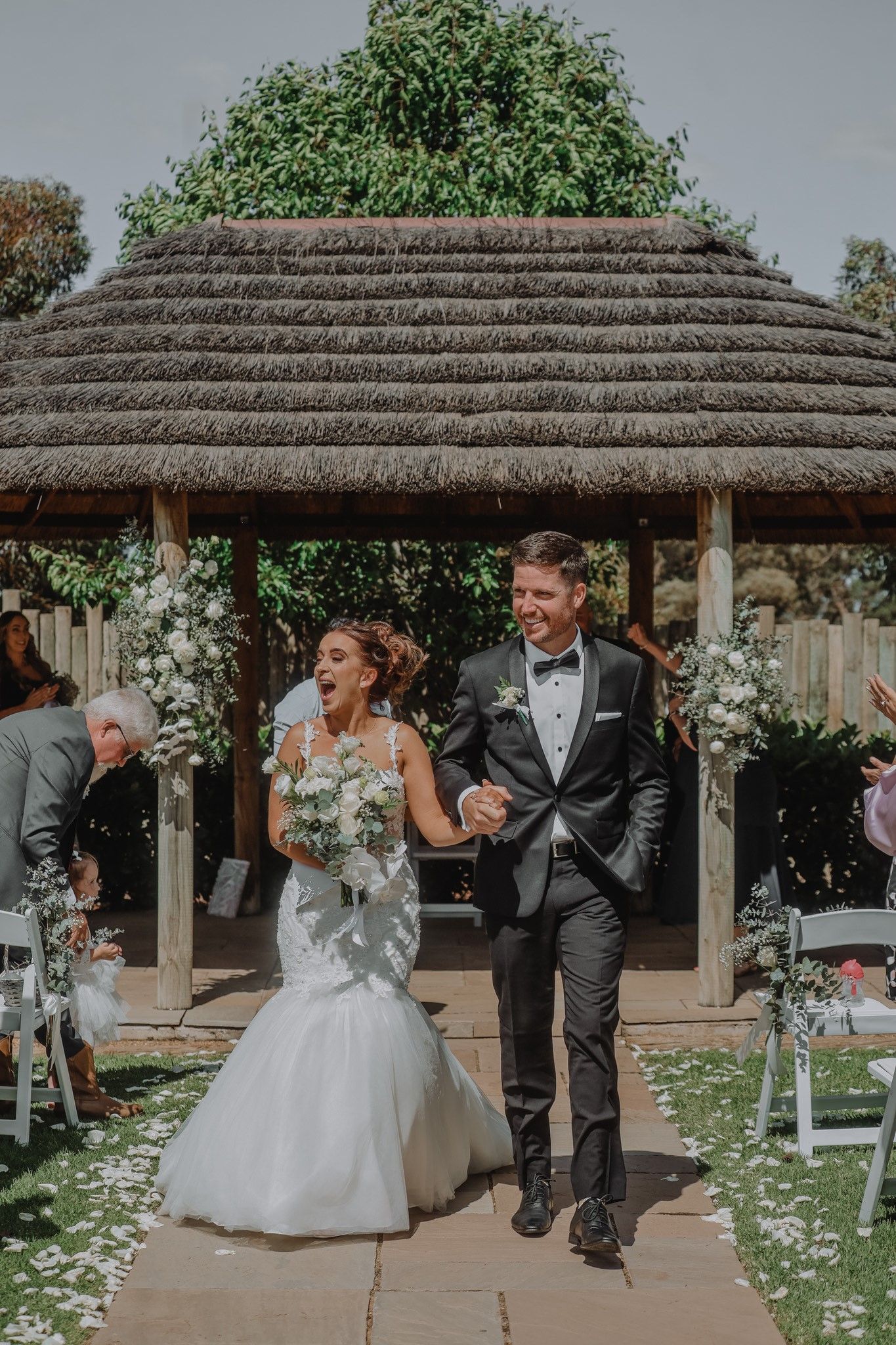 Newlyweds Smile at Each Other Holding a Colourful Bouquet — Denise's Flower Studio In Dubbo, NSW